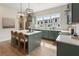 Sage cabinetry and quartz countertops highlight this bright kitchen with stainless steel appliances and an island at 508 Boardwalk Way, Alpharetta, GA 30022