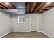 Unfinished basement with exposed ceiling, new flooring, a window for natural light, and a painted door at 847 Magna Carta Nw Dr, Atlanta, GA 30318