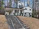 Split-level home with black and white trim, and a car port on a grassy lot with trees in the background at 847 Magna Carta Nw Dr, Atlanta, GA 30318
