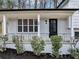 Charming front porch with black railing, newly painted white brick, and a sleek black door at 847 Magna Carta Nw Dr, Atlanta, GA 30318