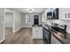 Well-lit kitchen features stainless steel appliances, black countertops, white cabinets, and light wood flooring at 847 Magna Carta Nw Dr, Atlanta, GA 30318