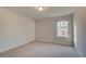 Carpeted bedroom featuring neutral walls, white door, and window with blind at 113 Belvedere Rd, Mcdonough, GA 30253