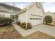 Ranch style home with light siding, an attached garage, and landscaping with flowering bushes at 1584 Snow Hill Dr, Lawrenceville, GA 30045