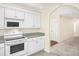 Well-lit kitchen featuring white cabinetry, stone countertops, and stainless steel oven at 1584 Snow Hill Dr, Lawrenceville, GA 30045