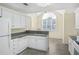Charming kitchen with white cabinets, granite countertops, and a large window above the sink at 1584 Snow Hill Dr, Lawrenceville, GA 30045