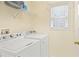 Functional laundry room includes a washer, dryer, shelving, and natural light at 1584 Snow Hill Dr, Lawrenceville, GA 30045