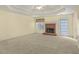 Carpeted living room features a brick fireplace, trey ceiling, and a glass door to the exterior at 1584 Snow Hill Dr, Lawrenceville, GA 30045