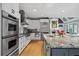 A spacious kitchen features stainless steel appliances, custom white cabinetry, granite countertops and a large island at 2728 Long Grove Dr, Marietta, GA 30062