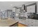 Close up of the gourmet kitchen featuring a gas range, stainless vent hood, and custom white cabinets at 2728 Long Grove Dr, Marietta, GA 30062