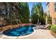 Relaxing backyard oasis featuring a private pool, stone accents, and comfortable lounge chairs surrounded by tall trees at 2728 Long Grove Dr, Marietta, GA 30062