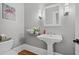 Tastefully designed powder room featuring a pedestal sink, elegant lighting, and fresh, neutral colors at 2728 Long Grove Dr, Marietta, GA 30062