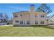 Spacious backyard view of the two-story home, featuring a large lawn and mature trees at 30 Barbara Ct, Fayetteville, GA 30215