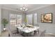 Elegantly staged dining room with a marble table, modern chandelier, and large window with natural light at 30 Barbara Ct, Fayetteville, GA 30215