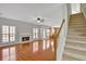 Bright living room featuring a fireplace, large windows, and hardwood floors leading to a staircase and open kitchen at 30 Barbara Ct, Fayetteville, GA 30215