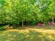 Lush backyard featuring mature trees and a well-maintained lawn, providing a serene outdoor space at 3621 Sutters Pond Way, Kennesaw, GA 30152