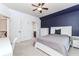 Bedroom with blue accent wall, white furnishings, ceiling fan, window, and neutral carpet at 3621 Sutters Pond Way, Kennesaw, GA 30152