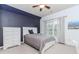 Bedroom with blue accent wall, white furnishings, ceiling fan, window, and neutral carpet at 3621 Sutters Pond Way, Kennesaw, GA 30152