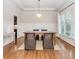 Inviting dining room boasts wood floors, wainscoting, a stylish chandelier, and natural light at 3621 Sutters Pond Way, Kennesaw, GA 30152