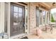 Inviting front door and window with dark shutters, with furniture, and red brick at 3621 Sutters Pond Way, Kennesaw, GA 30152