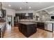 Modern kitchen featuring dark cabinets, island, stainless appliances, and adjacent breakfast area at 3621 Sutters Pond Way, Kennesaw, GA 30152