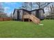 A home's backyard featuring a deck with stairs, a lush green lawn and a modern dark siding on the house at 875 Center Hill Nw Ave, Atlanta, GA 30318