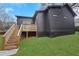 A home's backyard featuring a deck with stairs, lush green grass and dark colored siding on the house at 875 Center Hill Nw Ave, Atlanta, GA 30318