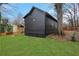 A home's backyard featuring a lush green lawn, dark siding, and a mature tree at 875 Center Hill Nw Ave, Atlanta, GA 30318