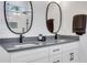 Close up of bathroom double vanity featuring a gray countertop, oval mirrors and modern fixtures at 875 Center Hill Nw Ave, Atlanta, GA 30318