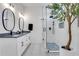 Bright bathroom features a double vanity, framed mirrors, and a walk-in shower with a blue accent tiled floor at 875 Center Hill Nw Ave, Atlanta, GA 30318