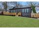 Modern house exterior showing dark facade, front wooden deck, green lawn, and side fence at 875 Center Hill Nw Ave, Atlanta, GA 30318