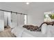 Bright main bedroom features hardwood floors, neutral walls, and sliding barn door to en-suite bathroom at 875 Center Hill Nw Ave, Atlanta, GA 30318