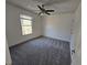 A cozy bedroom featuring neutral walls, carpet, ceiling fan and a window letting in natural light at 1734 Victoria Nw Way, Kennesaw, GA 30152