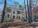 Two-story home with neutral colors, dark shutters, and a well-manicured front yard surrounded by mature trees at 1734 Victoria Nw Way, Kennesaw, GA 30152