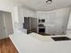 Bright kitchen features stainless steel appliances, white cabinets and a bar top that seats multiple people at 1734 Victoria Nw Way, Kennesaw, GA 30152