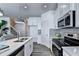 Bright kitchen with stainless steel appliances, quartz countertops, and modern finishes at 2704 Ne Almand Ln, Conyers, GA 30013