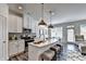 Eat-in kitchen featuring white cabinets, stainless steel appliances, and a large island with pendant lighting at 2704 Ne Almand Ln, Conyers, GA 30013