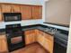 Functional kitchen featuring wood cabinets, black appliances, and a stainless steel sink at 3874 Austin Park Ln, Decatur, GA 30032