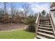 Backyard view featuring a staircase leading to the deck and lush greenery at 4126 Dream Catcher Dr, Woodstock, GA 30189