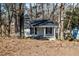 Charming single-story home with white siding, black shutters, and a cozy front porch nestled among trees at 100 Daisy Cir, Canton, GA 30114