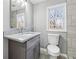 Updated bathroom featuring gray vanity with granite countertop, tile shower, and a window for natural light at 3482 Atlanta St, Atlanta, GA 30337