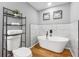 Bathroom featuring modern tub, toilet, and black accents with contemporary shelving at 3482 Atlanta St, Atlanta, GA 30337