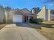 Charming single-story home with attached garage and manicured front yard landscaping at 7175 Bowie Dr, Lithonia, GA 30038