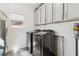 Well-organized laundry room with sleek gray cabinets, modern washer and dryer, and stylish flooring at 853 Gaston Sw St, Atlanta, GA 30310