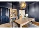Chic office featuring dark walls, light wood desk, decorative shelving, and modern pendant lighting at 853 Gaston Sw St, Atlanta, GA 30310