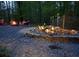 Relaxing backyard with a stone fire pit, red Adirondack chairs, a waterfall and lush landscaping at 15 Winterville Dr, Rockmart, GA 30153