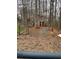 View of the wooded backyard with a shed and a rustic gate at 15 Winterville Dr, Rockmart, GA 30153