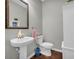 Powder room featuring a pedestal sink, bronze mirror, and wood-look flooring at 2735 Kimblewick Ct, Cumming, GA 30040