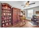 Inviting office with natural light, ceiling fan, built-in shelves, wood floors, and dark wood furniture at 2735 Kimblewick Ct, Cumming, GA 30040
