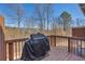 Outdoor patio with a wooden deck featuring a grill and wooded views at 2735 Kimblewick Ct, Cumming, GA 30040