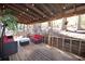 Cozy covered porch offers comfortable seating, string lights, and a charming wooded view for relaxation and entertainment at 671 Benson Hurst Sw Dr, Mableton, GA 30126